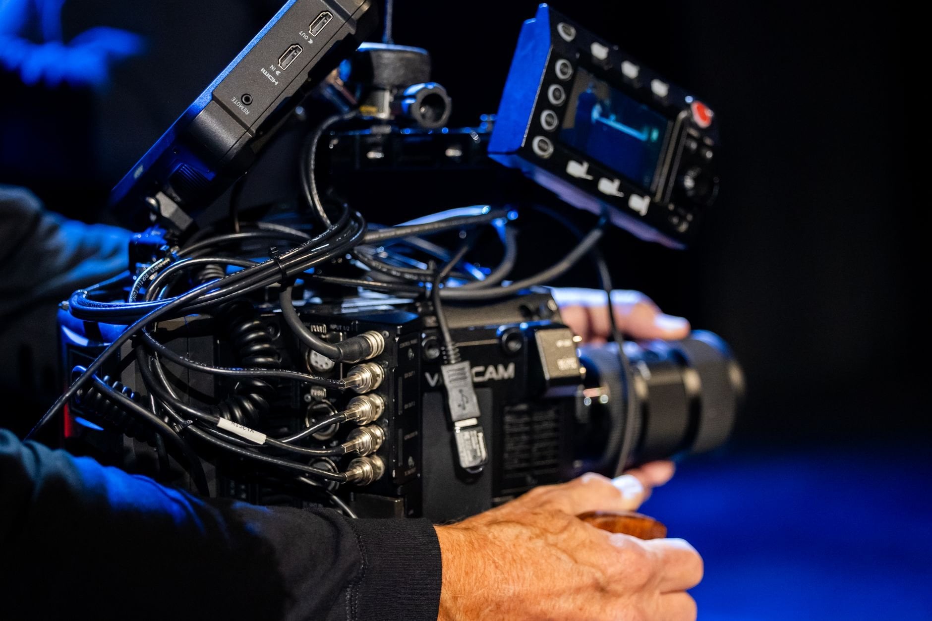 Close-up of a professional videographer handling a cinema camera during filming.