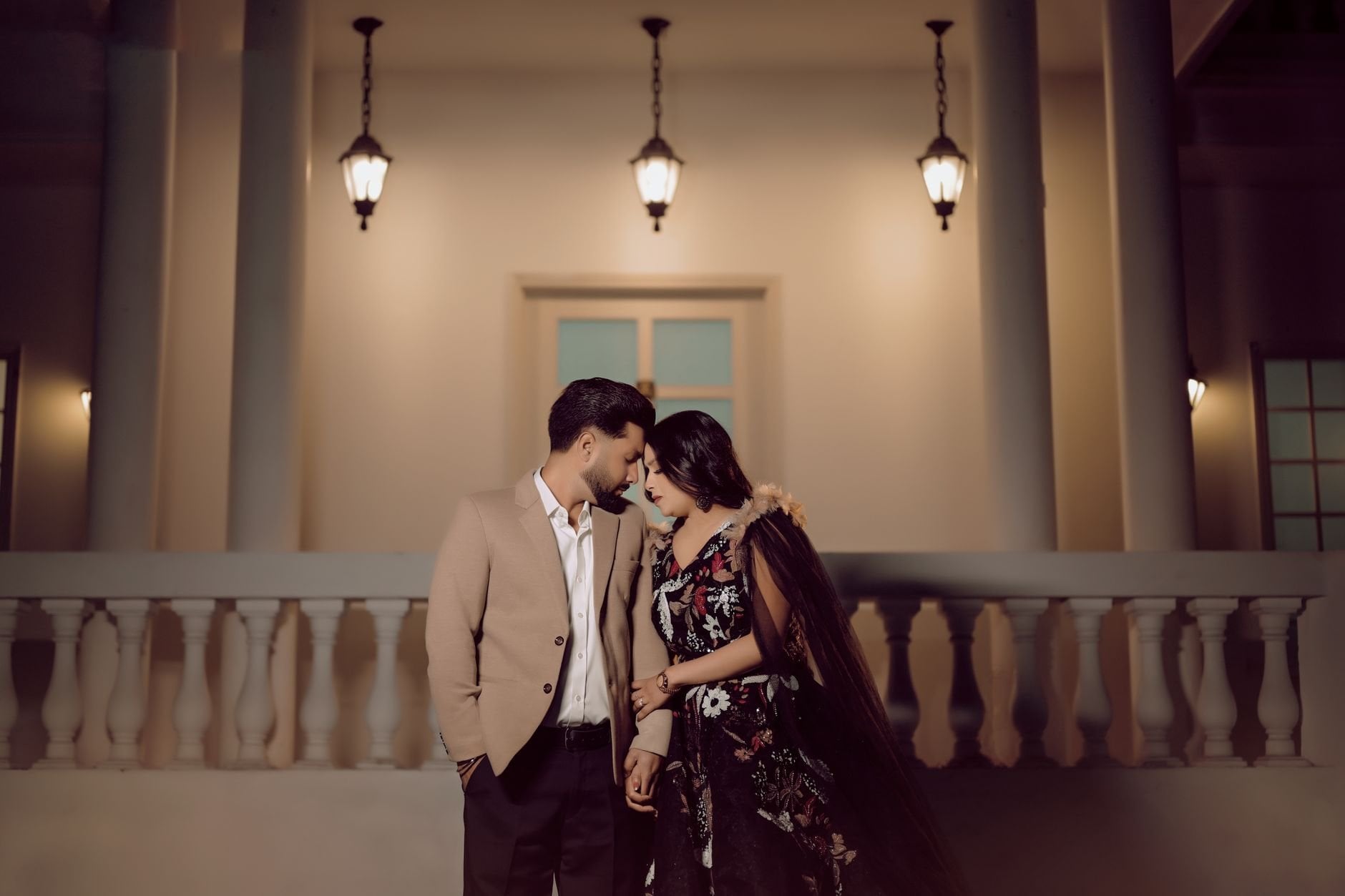Elegant couple portrait under warm lantern light.