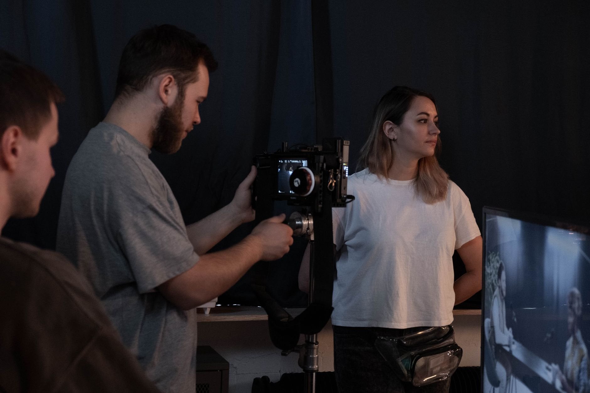 A team setting up a video recording with professional equipment in a studio.